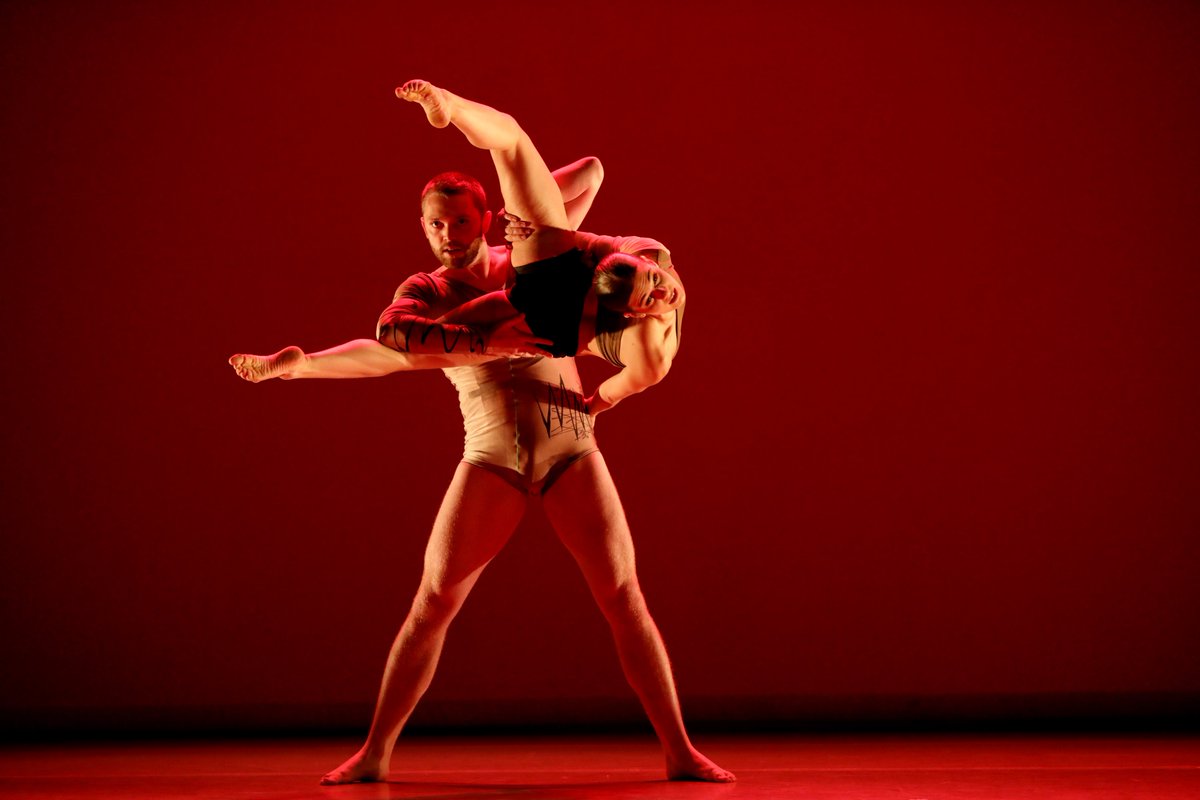 two dancers perform over head lift 