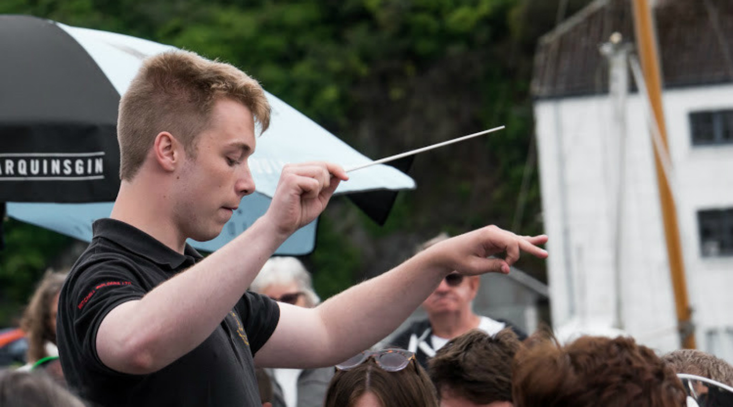 Harry Weird conducting an ensemble at an outside event