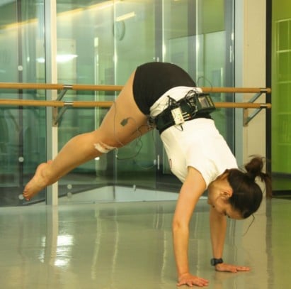 Girl in handstand while wearing dance science equipment to measure muscle activity