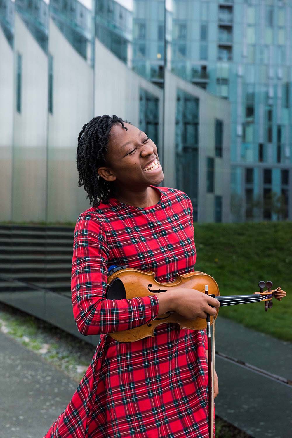 Student Aanu Sodipe smiling and holding a violin
