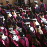 Cohort of students in caps and gowns.