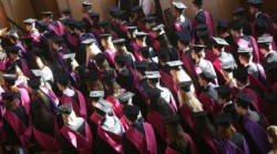 Seated graduates in robes and mortar boards