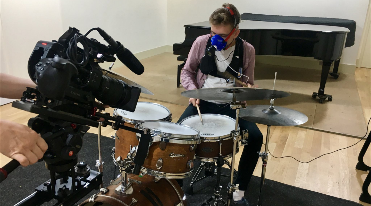 Musician being analysed with a gas analyser whilst playing the drums