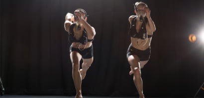 Two dancers in a darkened studio performing with gad analysers on
