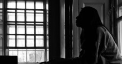 Women sat in side profile silhouette in front of big window