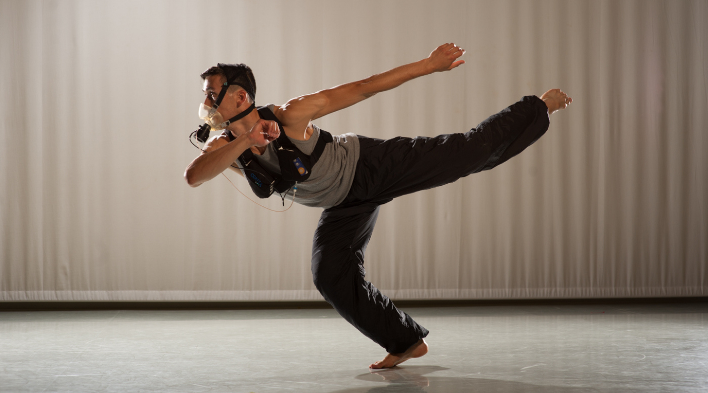 Dancer performing in a studio with gas analyser on face.