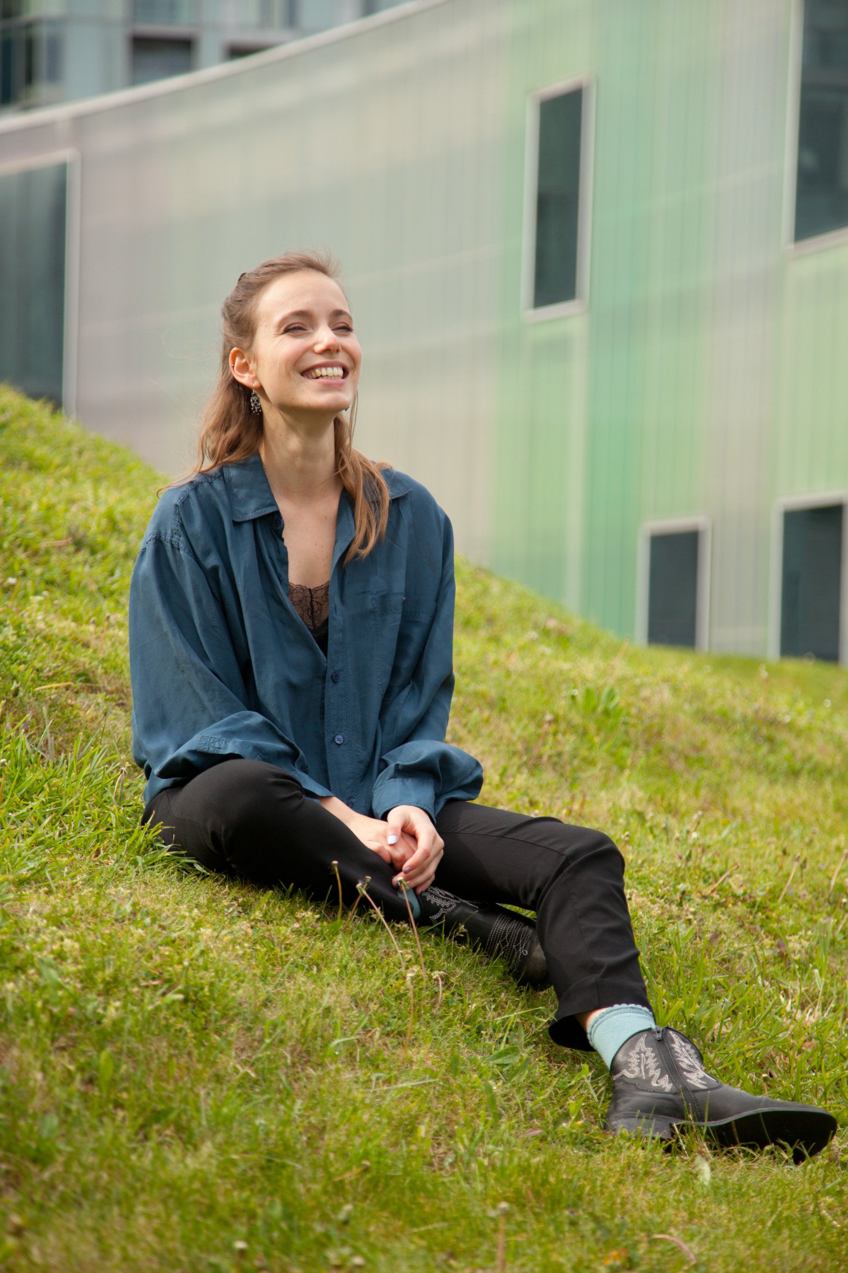 Laudine Dard sitting on grass verge smiling
