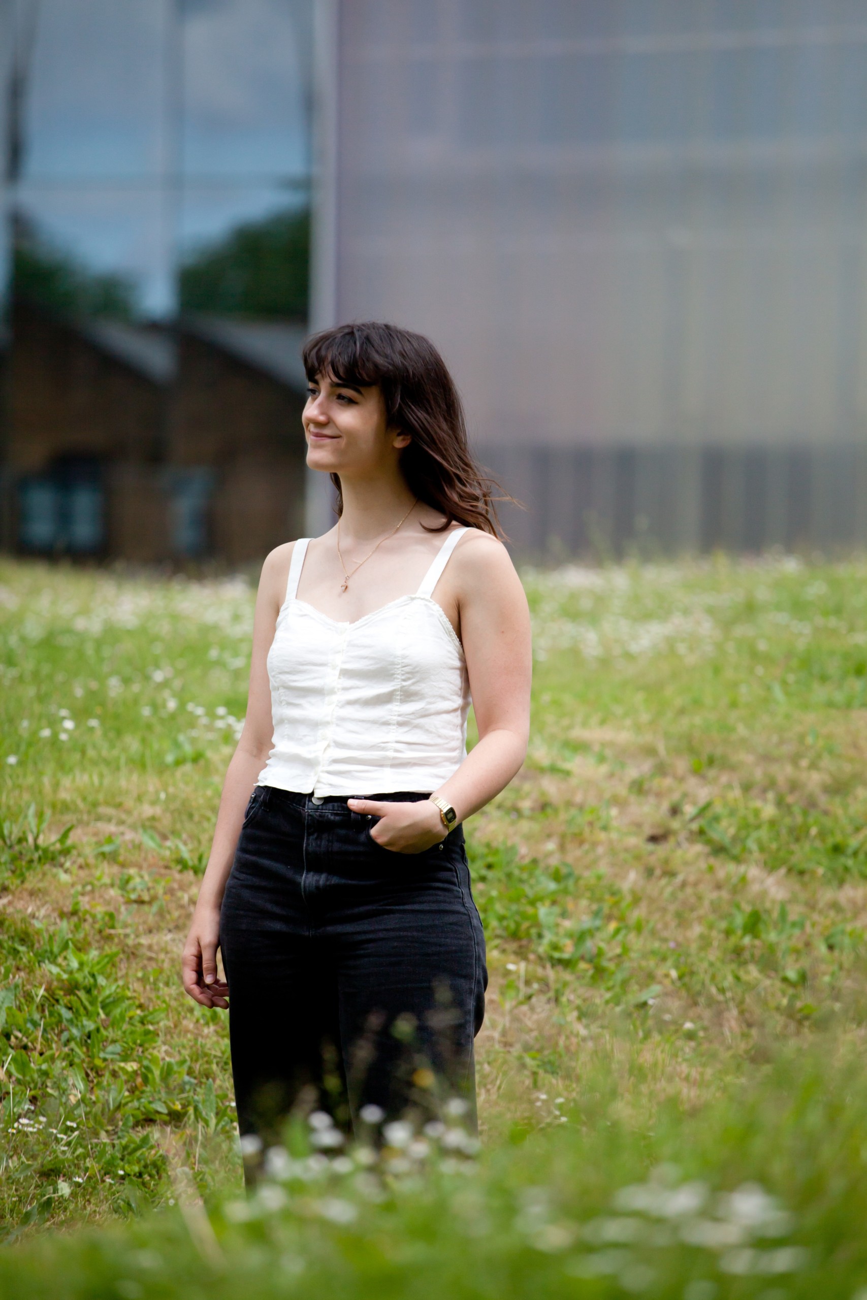 Myra Brownbridge standing in grassy field with left hand in pocket