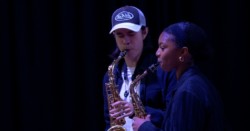 Two saxophone students playing side by side