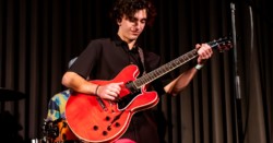 Male student playing electric guitar