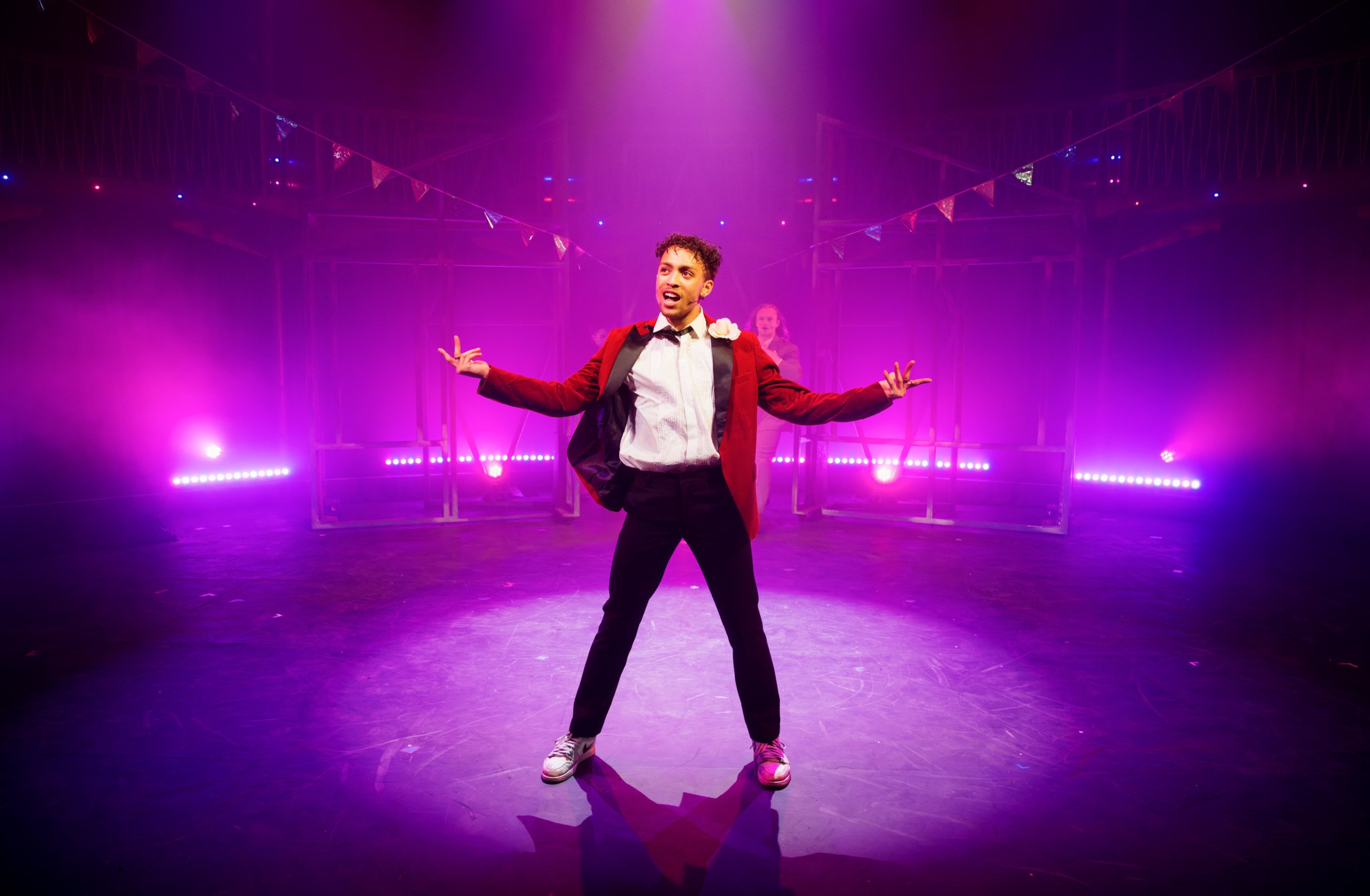 Image of a young musical theatre performer dressed in a red tuxedo with a white corsage taken during Trinity Laban's Musical Theatre's production of Footloose (2009). credit Alex Brenner