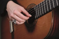 Close up of a hand plucking a classical guitar